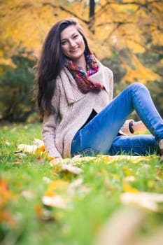 girl sitting on the grass in the autumn Park