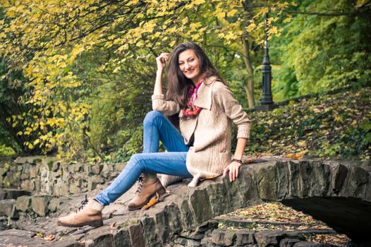 girl sitting on a stone bridge in the Park