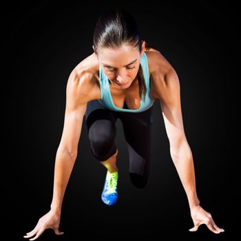 Sportswoman in the starting block in a black background