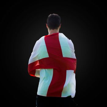 Rear view of sportsman holding an England flag in a black background