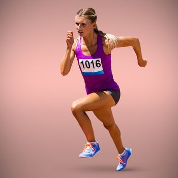 Athletic woman in running position against pastel pink