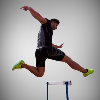 Athletic woman practicing show jumping against grey vignette