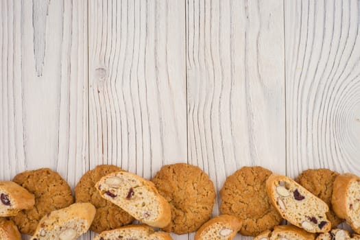 Different cookies on an old white wooden table. Top view.