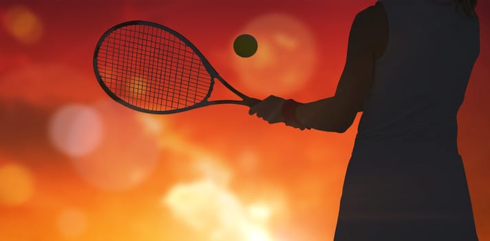 Athlete playing tennis with a racket  against landscape with sunset