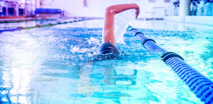 Fit swimmer doing the front stroke in the swimming pool at the leisure center