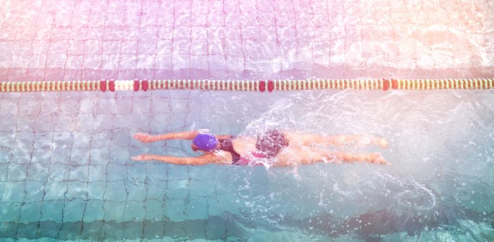 Female swimmer training by herself in swimming pool at the leisure centre