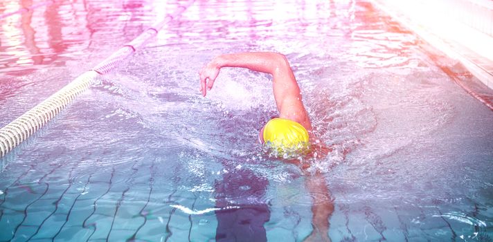 Fit man swimming with swimming hat in swimming pool