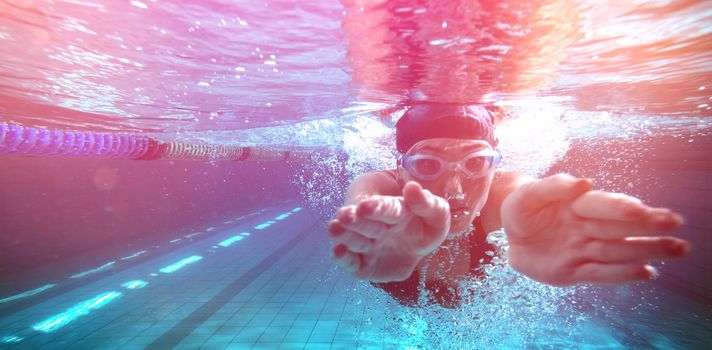 Athletic swimmer training on her own in the swimming pool at the leisure centre