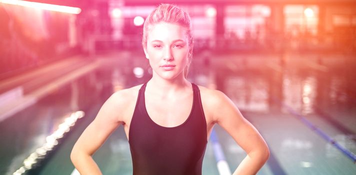 Fit woman with hands on hips at the pool
