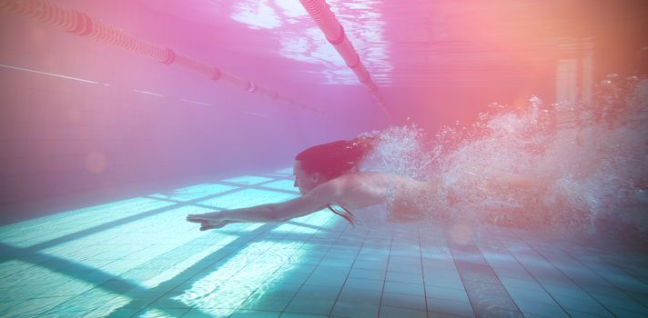 Pretty swimmer swimming underwater in bikini in the swimming pool at the leisure centre