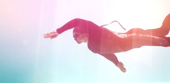 Young man with arm raised while swimming underwater