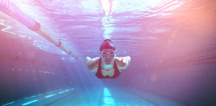 Athletic swimmer training on her own in the swimming pool at the leisure centre