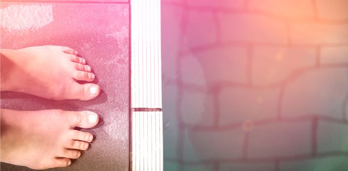 Feet of woman standing on the edge of the pool at the leisure center
