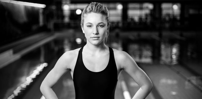 Fit woman with hands on hips at the pool