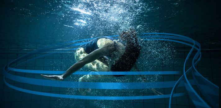 Athletic swimmer doing a somersault underwater against feet of woman standing on the edge of the pool