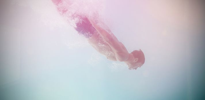 Side view of shirtless man swimming underwater