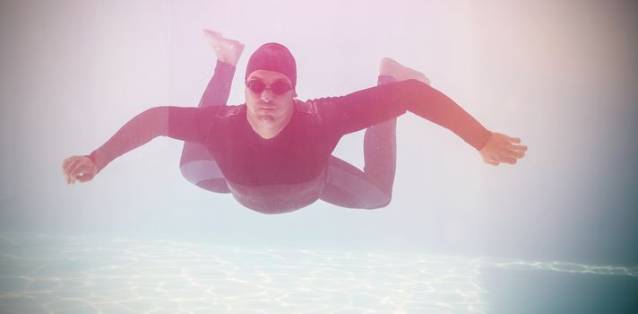 Young man with arms outstretched while swimming underwater