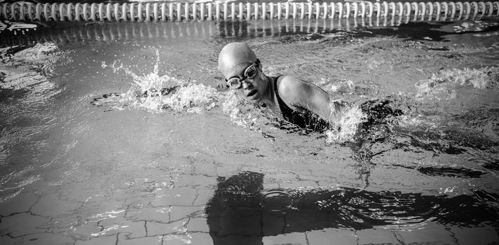 Side view of swimmer woman swimming in the swimming pool