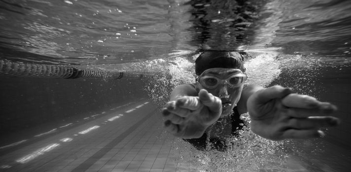 Athletic swimmer training on her own in the swimming pool at the leisure centre