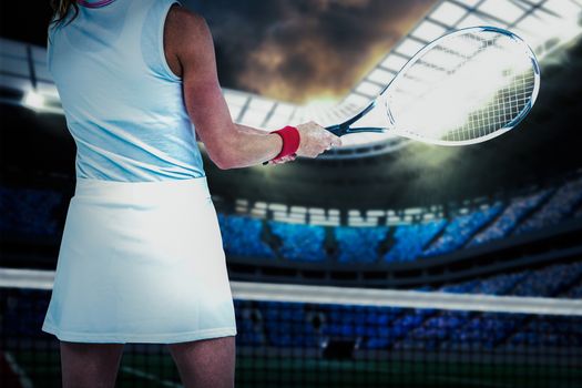 Athlete playing tennis with a racket  against digitally generated image of tennis court in arena