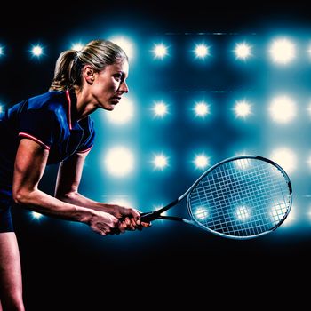Tennis player playing tennis with a racket  against digitally generated image of blue spotlight 
