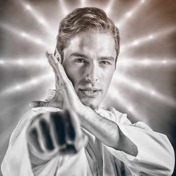 Portrait of fighter performing karate stance against spotlights