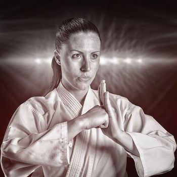 Female fighter performing hand salute against spotlight