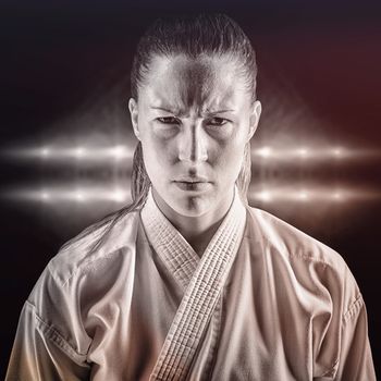 Female fighter on black background against spotlights