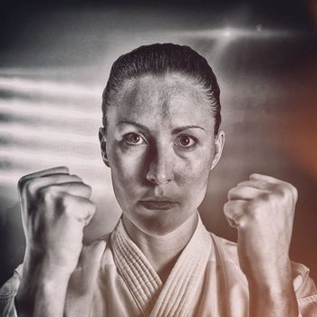 Female fighter performing karate stance against spotlight