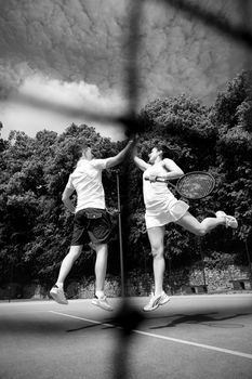 Tennis doubles team celebrating a win on a sunny day