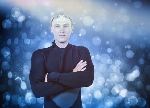 Portrait of swimmer in wetsuit against blue abstract light spot design