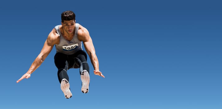 Front view of sportsman is jumping  against scenic view of blue sky
