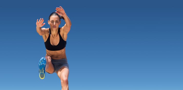 Sportswoman jumping on a white background against scenic view of blue sky