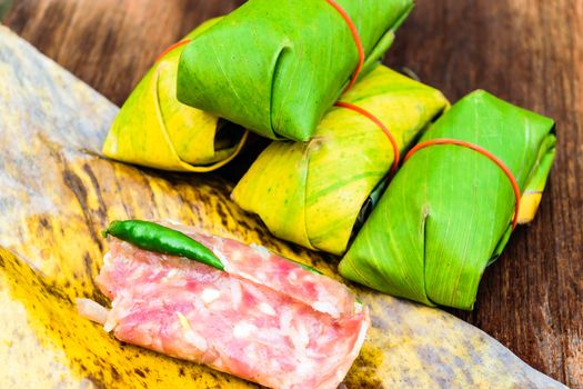 Sour pork Thai northeastern style food which mixed pork rice garlic sugar and salt in banana leaf package.