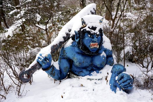 Blue giant myth sculpture at Noboribetsu onsen snow winter national park in Jigokudani, Hokkaido, Japan