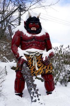 Red giant myth sculpture at Noboribetsu onsen snow winter national park in Jigokudani, Hokkaido, Japan