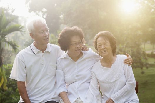 Portrait of healthy Asian seniors group having good time at outdoor nature park, in morning beautiful sunlight at background.