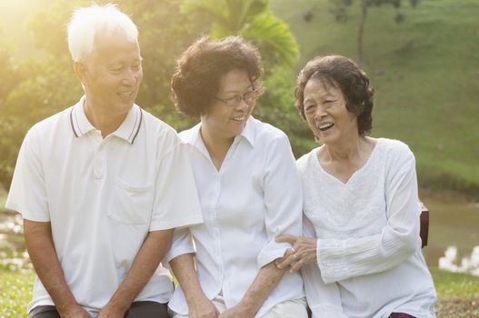 Portrait of healthy Asian seniors group having fun at outdoor nature park, in morning beautiful sunlight at background.
