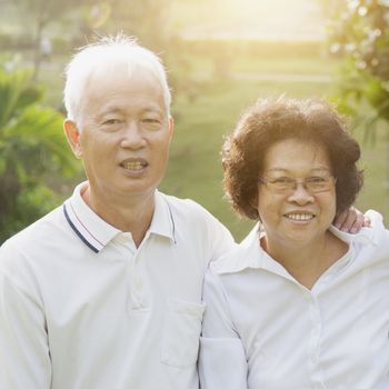 Portrait of healthy Asian seniors retiree couple having fun at outdoor nature park, morning beautiful sunlight background.