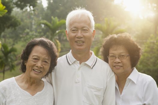 Group of healthy Asian seniors enjoy retired life at outdoor nature park, in morning beautiful sunlight at background.