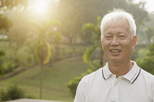 Portrait of healthy Asian senior man at outdoor nature park, morning beautiful sunlight background.