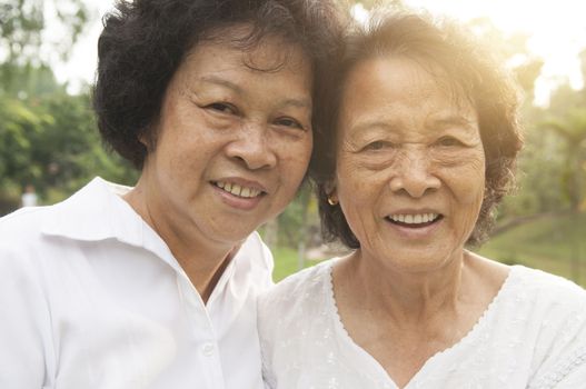 Portrait of healthy happy Asian seniors mother and daughter having fun at outdoor nature park, morning beautiful sunlight background.