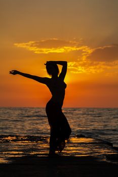 Girl jumping on a background of sea sunset