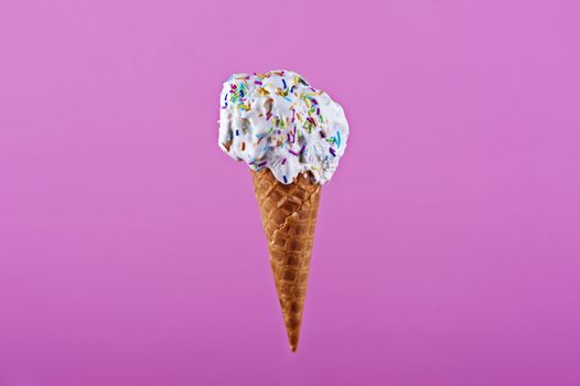 Ice cream in wafer cone isolated on pink background