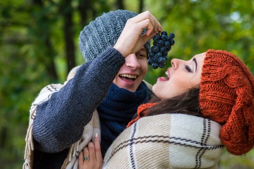 young couple eats grapes in the garden