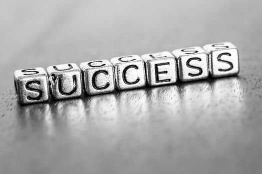 success letters placed on a desk in precious wood