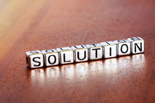 solution letters placed on a desk in precious wood