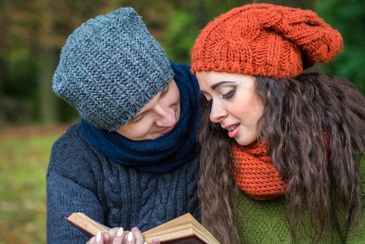 loving couple reads a book in the autumn garden