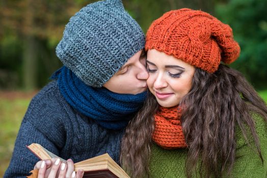 loving couple reads a book in the autumn garden