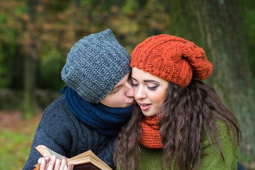 loving couple reads a book in the autumn garden